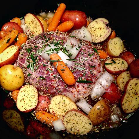 Pork tenderloin roast with baby carrots, white onion & mini potatoes. Seasoned with herbs, spice ...