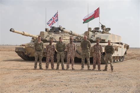 A British tank crew of the Royal Tank Regiment stands next to Royal Omani Army tank crewmen ...