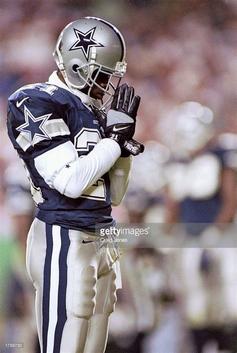 Cornerback Deion Sanders of the Dallas Cowboys prays while standing ...