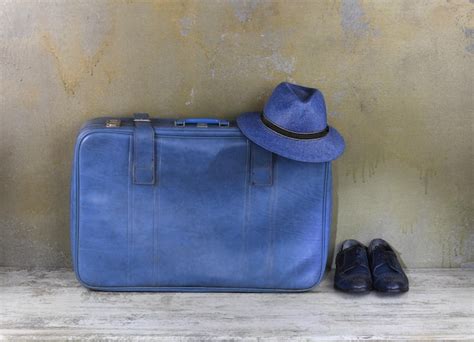 Premium Photo | Blue suitcase on wooden floor
