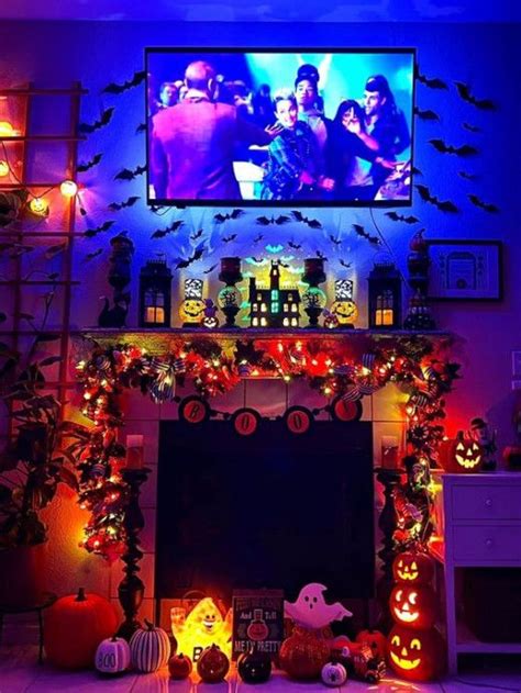a living room decorated for halloween with pumpkins and decorations on the fireplace mantel