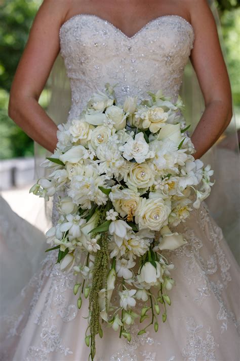 Cascade bouquet with white orchids, white peonies, cream roses, white stephanotis, white tulips ...