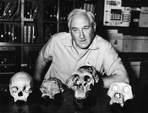 circa 1955: British anthropologist Dr Louis S B Leakey (1903 - 1972) sits at a table with four ...