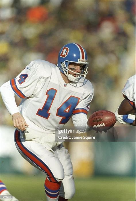 Quarterback Bill Musgrave of the Denver Broncos hands off the ball ...