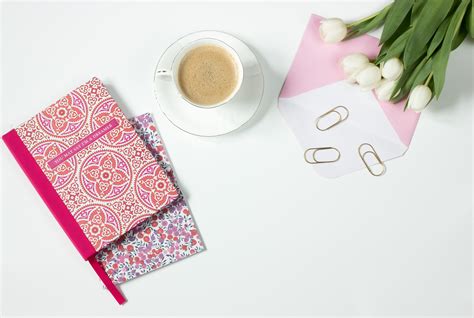 Personal organizer and pink flowers on desk · Free Stock Photo