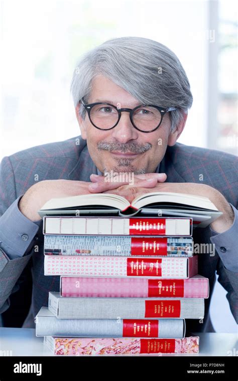 Man leaning on a book pile Stock Photo - Alamy