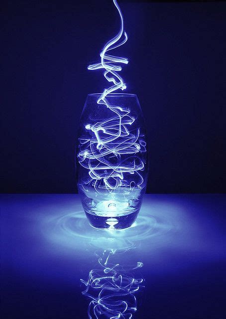 a glass vase sitting on top of a blue table next to a lit candle holder