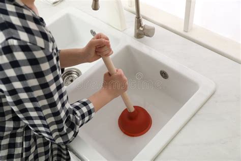 Woman Using Plunger To Unclog Sink Drain in Kitchen, Closeup Stock ...