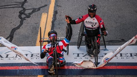 Marathon handcycle winners hold hands for tie finish