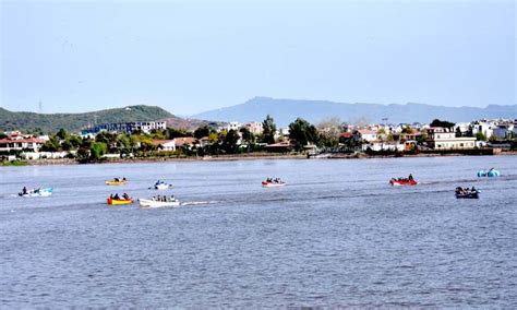 Visitors enjoy boating in Rawal Lake during a Sunny day