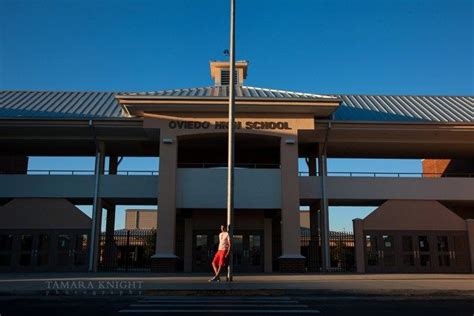 The Graduate {by Orlando Photographer} Teenage boy is leaning on flagpole in front of Oviedo ...