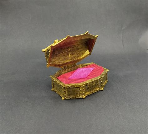 an open wooden box with pink paper inside on a gray surface, showing the lid