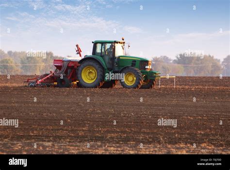 Tractor on field at sunset Stock Photo - Alamy