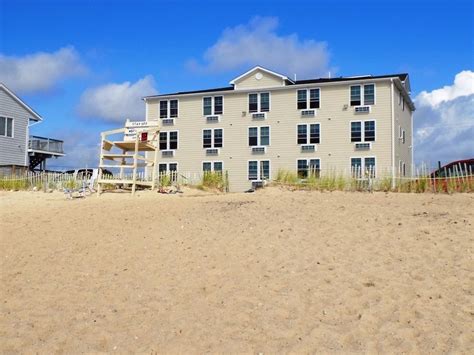 two beach houses sitting on the sand next to each other