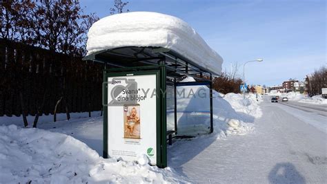 A bus stop full of snow in one of the snowy streets in the center of ...