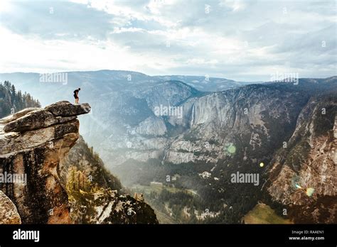 A fearless hiker is standing on overhanging rock at Glacier Point ...