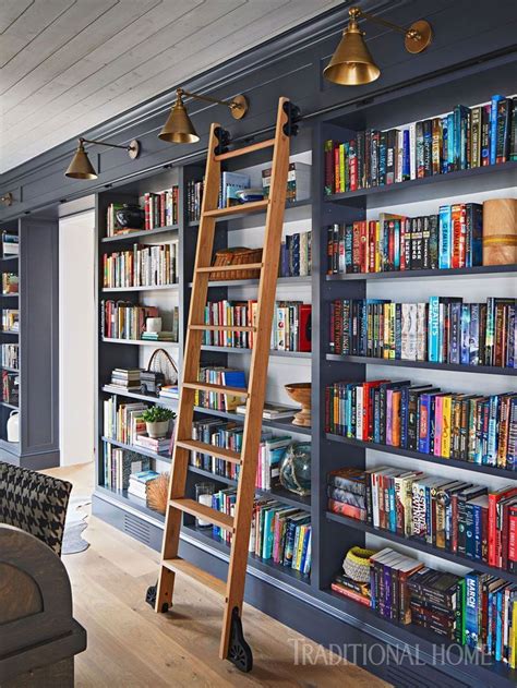 A wall of built-in bookshelves is a bookworm's delight. A custom sliding ladder enhances the ...