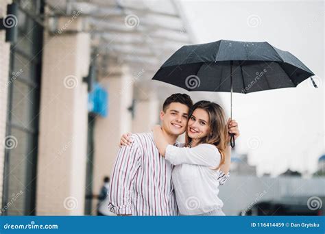 Happy Young Couple Embracing Under Umbrella in Rain Day. Couple in Love Relationships Concept ...