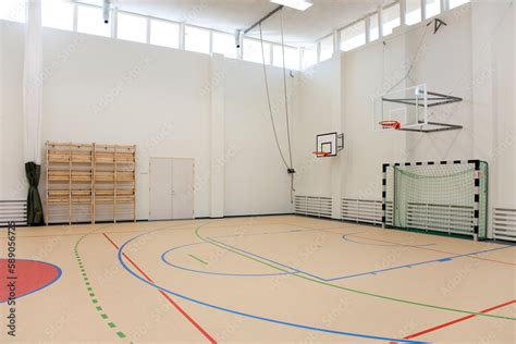 Indoor basketball court at a school. Wooden floor and marked court, a hoop and backboard. Stock ...