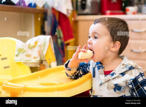 Funny boy 2 years with a banana in his mouth. Boy 2 years old eating banana. Baby 2 years old ...