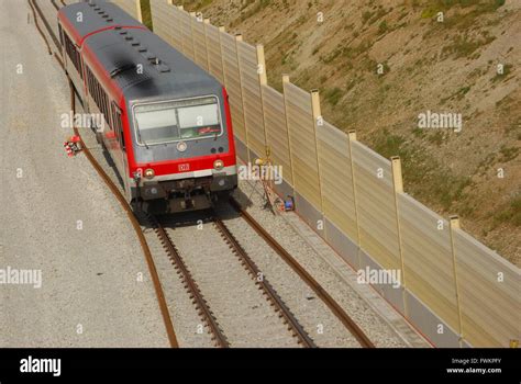 Local train drives along noise reduction wall at a construction site Stock Photo - Alamy