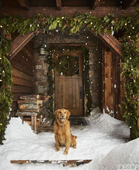 A golden retriever sits at the front door of this cozy Montana log cabin in the mountains ...