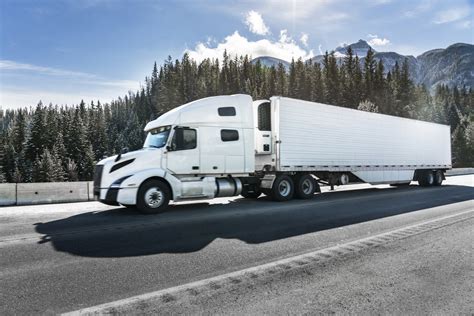 a white semi-truck driving on mountain road - Meduli Nature