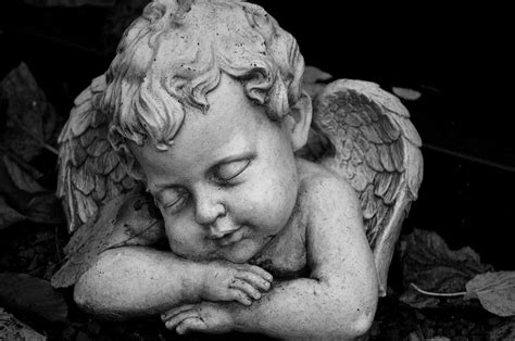 A Grayscale of a Statue of a Baby Angel · Free Stock Photo