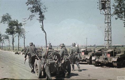 German troops pulling a 37mm Pak 36 anti-tank gun along a road near ...