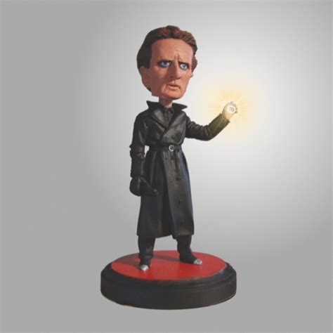 a bobble head figure holding a glowing light in one hand and wearing a trench coat