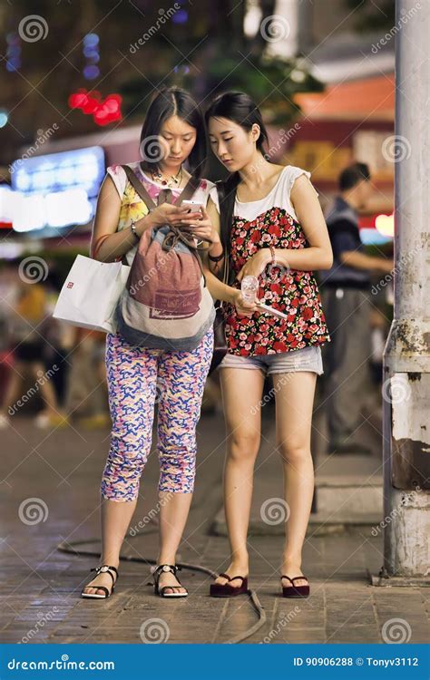 Two Trendy Girls Busy with Smart Phone in Downtown Area, Kunming, China Editorial Stock Photo ...