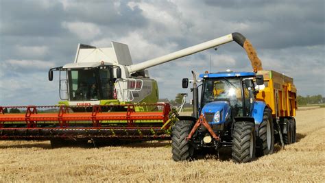 Blue Tractor Next to White Farm Vehicle at Daytime · Free Stock Photo