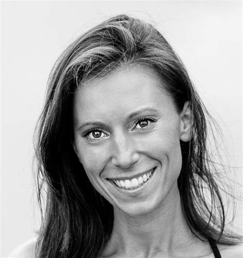 a black and white photo of a woman with long hair smiling at the camera ...