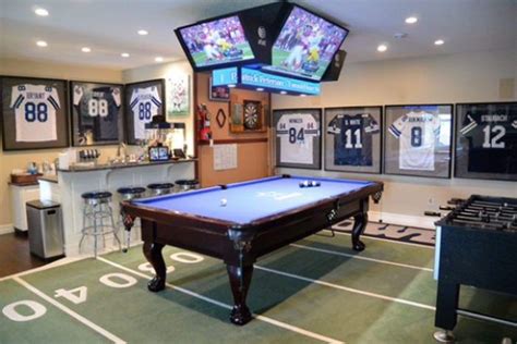 a man cave with a pool table and televisions on the wall, sports memorabilia