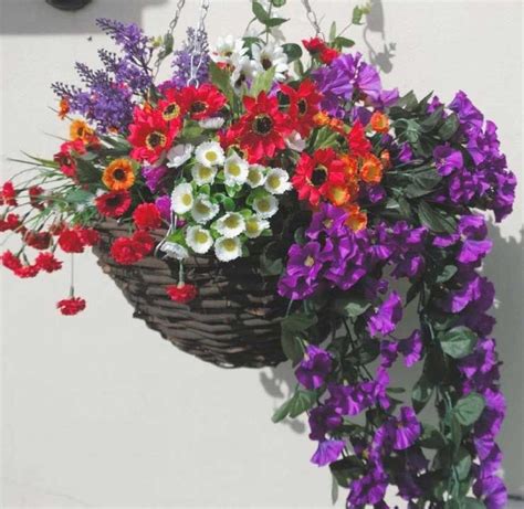 A very bright and cheerful artificial hanging basket with different flowers in red, white ...