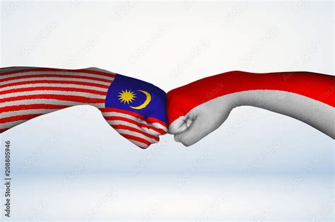 Fist bump of Malaysian and Indonesian flags. Two hands with painted ...