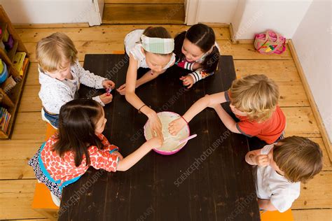 Children sharing food in kitchen - Stock Image - F005/3331 - Science Photo Library