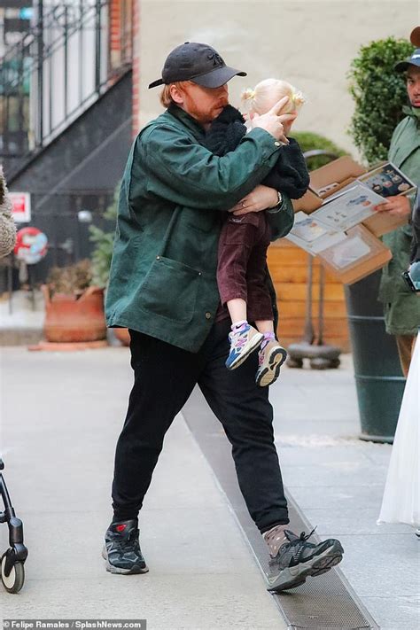 Rupert Grint carries his daughter Wednesday during a stroll in New York ...