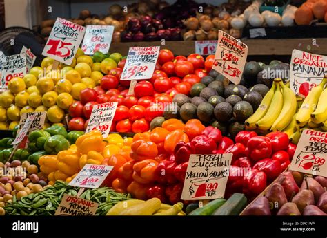 Display of fruits and vegetables with signs at a produce market stall ...