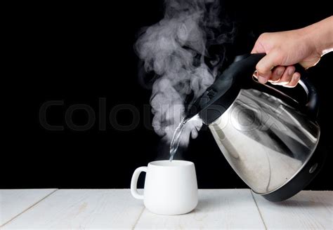 Kettle pouring boiling water into a cup ... | Stock image | Colourbox