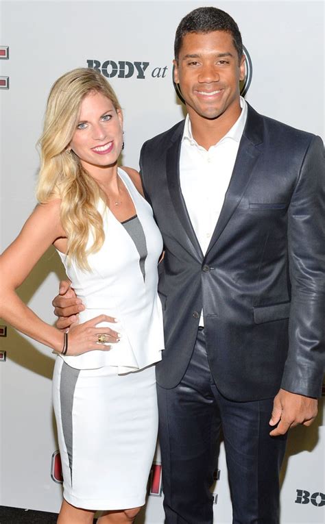 Ashton Meem wearing white outfit and Russell Wilson wearing black suit