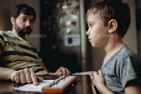 Little boy doing math homework, calculating with abacus (soroban) Stock Photo by uraneva