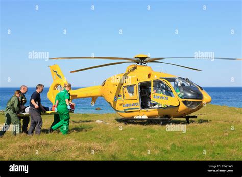 UK Scottish Air Ambulance Service Helicopter paramedics rescuing a woman on a stretcher on the ...