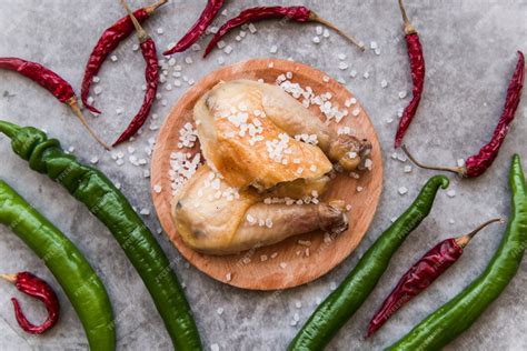 Free Photo | High angle view of baked chicken garnish with salt and chilies over concrete background