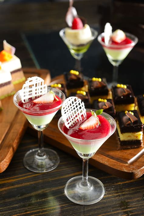 desserts are arranged in small glasses on a tray