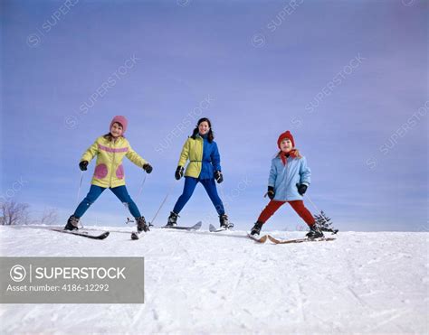 1960S Mother And Two Daughters Skiing Together Winter Outdoor - SuperStock