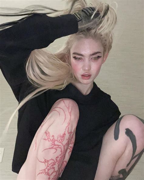 Grimes debuts fresh 'alien scar' chest tattoos, chipped tooth