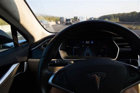 Display of a Tesla car on autopilot mode showing current speed, remaining estimated range, speed ...