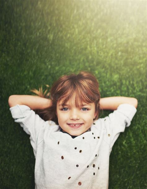 Happy, Top View and Portrait of Child on Grass for Relaxing, Playful Fun and Happiness in Garden ...