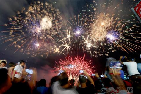 Revelers watch as fireworks light up the sky to welcome the New Year ...